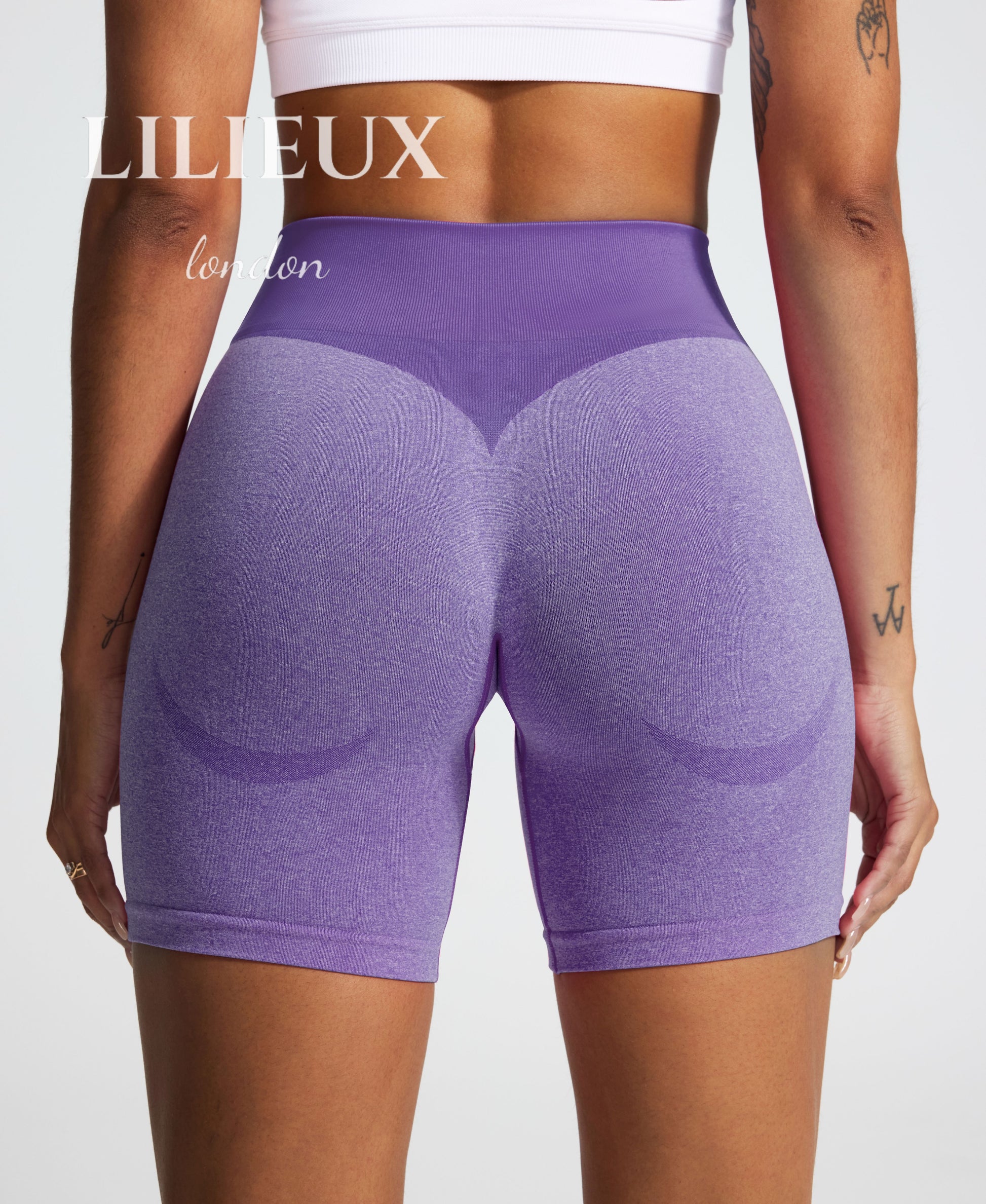 Back view of high-waisted purple scrunch-butt gym shorts, featuring a ribbed compression waistband and contouring seamless fabric for a flattering and supportive fit."