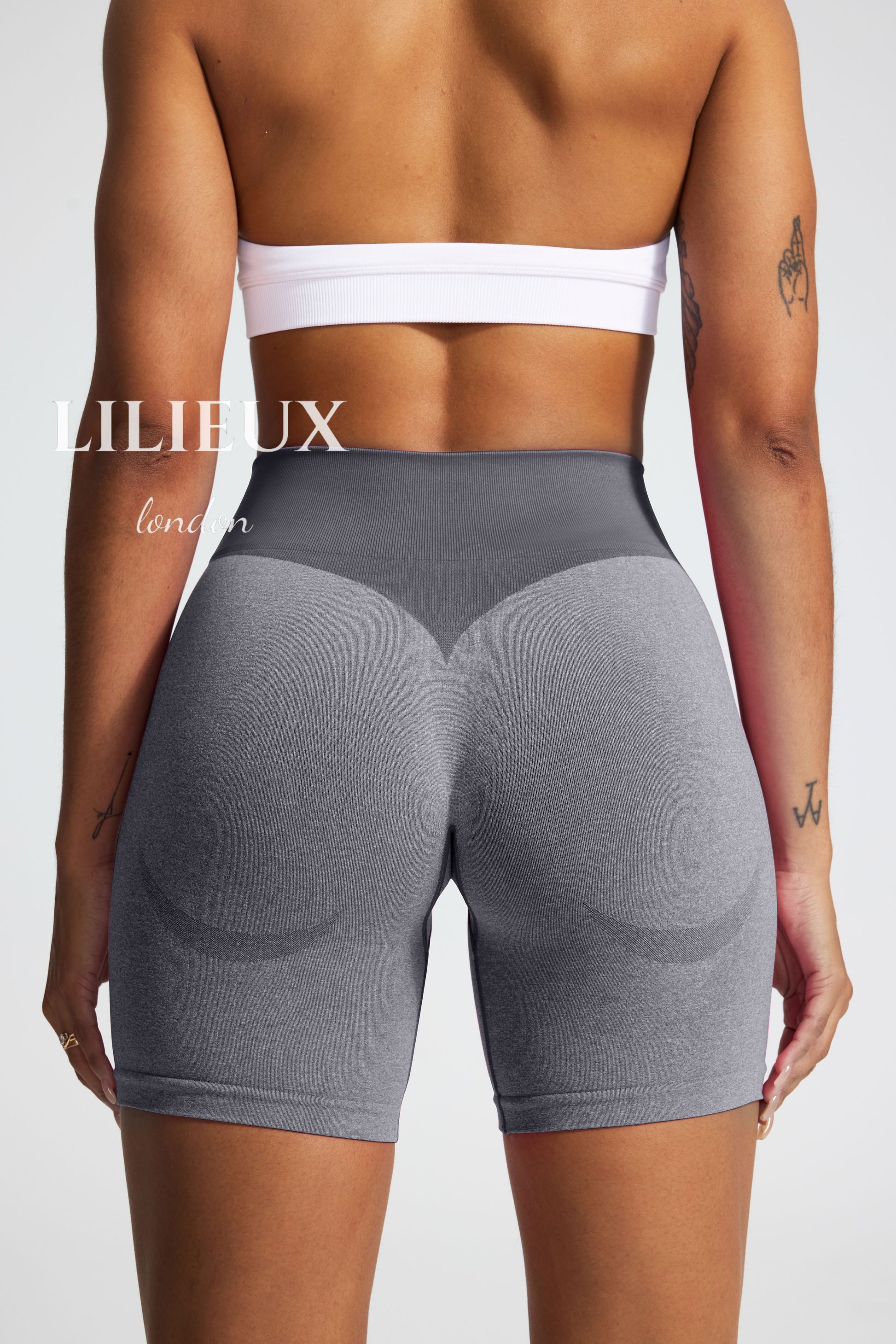 Back view of high-waisted grey scrunch-butt biker shorts, featuring a ribbed compression waistband and seamless fabric for a flattering and supportive gym fit."
