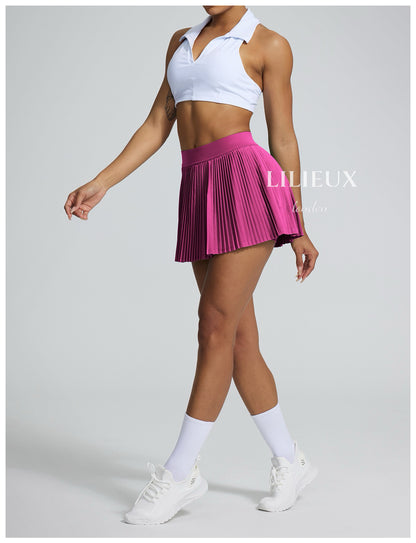 Female tennis player wearing a white sports bra and pink pleated skirt, paired with white sneakers and socks, presenting a vibrant and sporty look.